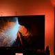 The Philips Hue Sync Box shining behind a TV.